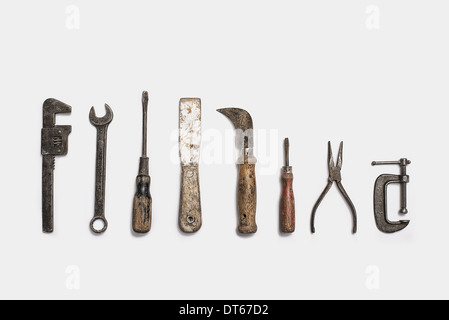 Used tools arranged in a row. Well used, worn handles, shaped wooden smooth texture. Metal rusty and marked implements. Stock Photo