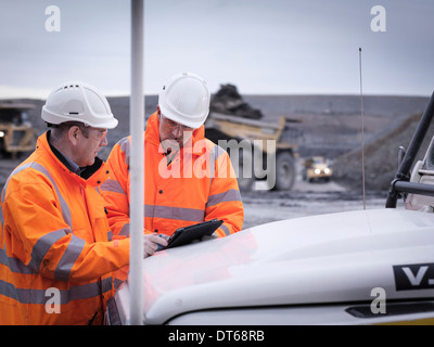 Geologists discuss plans on digital tablet in surface coal mine Geologists discuss plans on digital tablet in surface coal mine