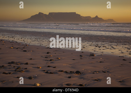 Table Mountain and the outline of Devil's Peak and Lion's Head, viewed from the shores of Blouberg beach in Western Cape. Stock Photo