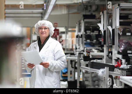 Female scientist holding paperwork in laser laboratory Stock Photo