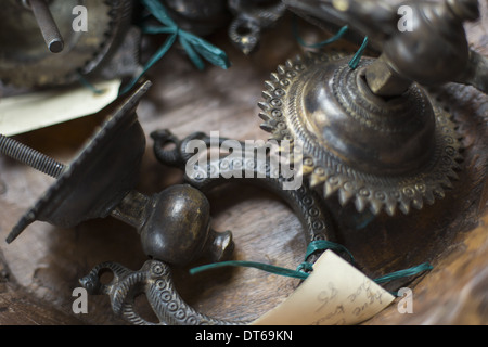An antique store with a display of objects and furniture Chased metal decorated objects, door knocker and light fitting. Stock Photo