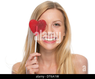 Smiling young woman with heart shaped lollipop Stock Photo