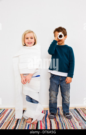Studio shot of sister and brother with toilet rolls Stock Photo