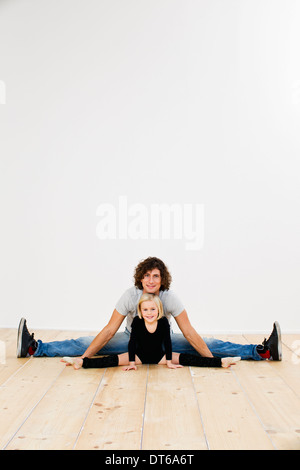 Studio portrait of father and ballerina daughter doing splits Stock Photo