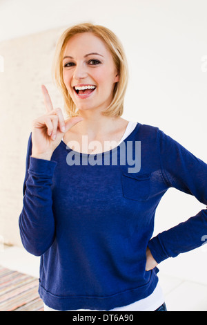 Studio portrait of young woman pointing finger Stock Photo