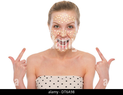 Happy young woman pointing on oatmeal mask Stock Photo