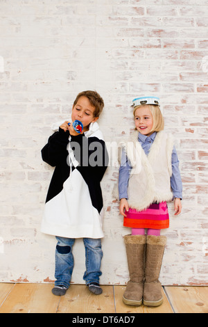 Studio shot of brother and sister in oversize clothes Stock Photo