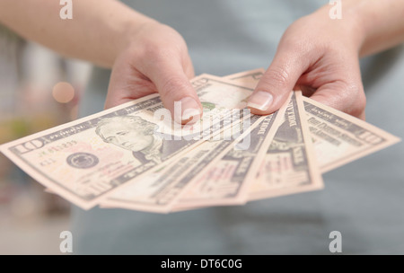 Female hands holding ten dollar notes Stock Photo