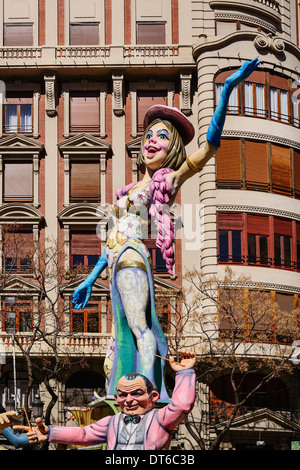 Spain, Valencia, Papier Mache figure of a woman standing on another figures shoulders in the street during Las Fallas festival. Stock Photo
