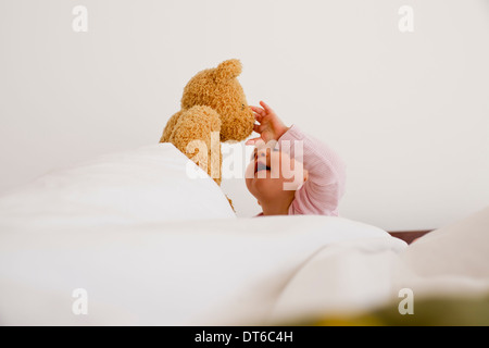 Baby girl playing with teddy bear Stock Photo