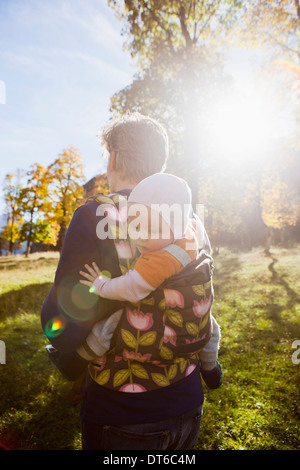 Father carrying baby daughter in carrier Stock Photo