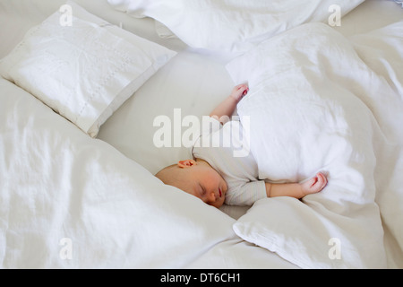 Baby girl asleep in bed Stock Photo