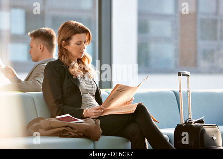 Businesswoman in departure lounge Stock Photo