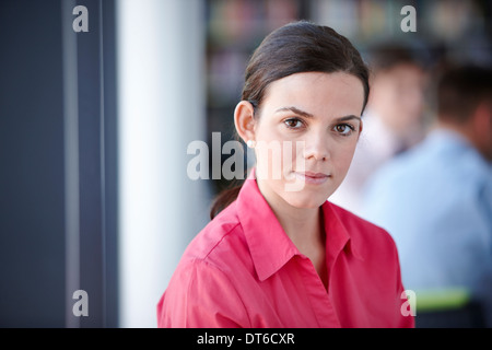 Young woman in a red top, black hot pants and high heels standing in front  of a tree Stock Photo - Alamy
