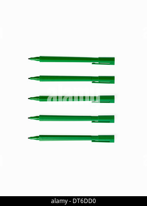 Office supplies. Green coloured pens, felt nibs and pen top cases, arranged in a row. Stock Photo