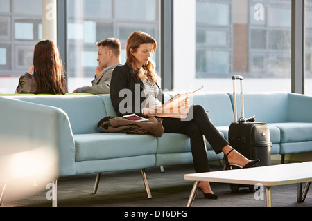 Businesswoman in departure lounge Stock Photo