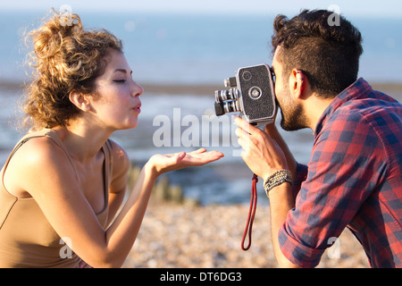 Young man filming woman with vintage camera Stock Photo