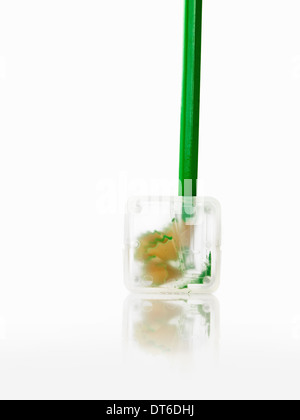 A green pencil and clear plastic pencil sharpener. Stock Photo