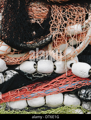 A pile of commercial fishing nets on a quay, white and red plastic