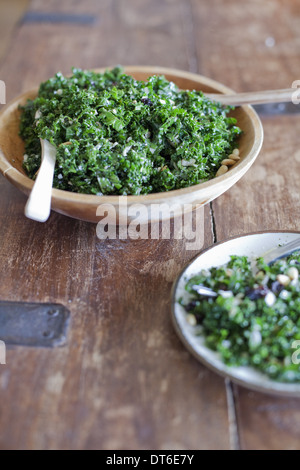 A wooden kitchen tabletop. Two plates of fresh green salad vegetables. Organic fresh food. Stock Photo
