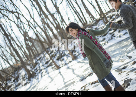 A couple hand in hand, on a snowy path through the woods. Stock Photo