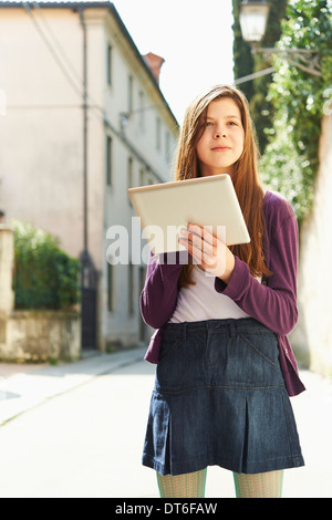 Girl with digital tablet on street, Province of Venice, Italy Stock Photo