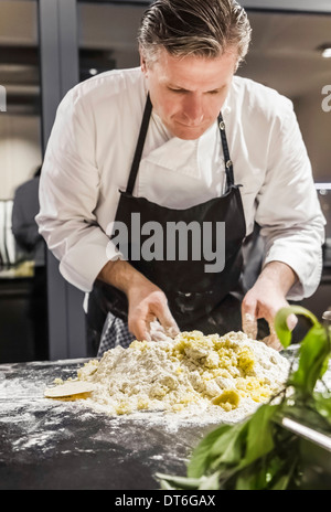 Chef mixing gnocchi dough in commercial kitchen Stock Photo