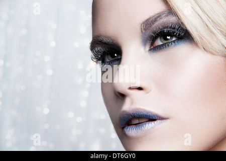 Close up of woman against glittery background Stock Photo