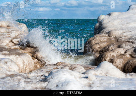 Waves come to shore at a frozen Oak Street Beach in Chicago, Illinois. Stock Photo