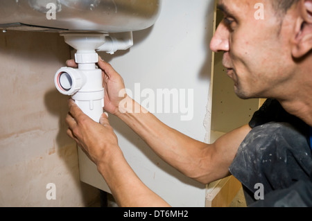 Man fitting sink waste water trap Stock Photo