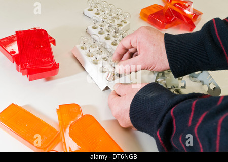 Man assembling automotive lights in a factory production line Stock Photo