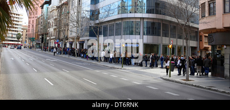 People await in queue their turn to apply for a job offer in the island of Mallorca, Spain Stock Photo