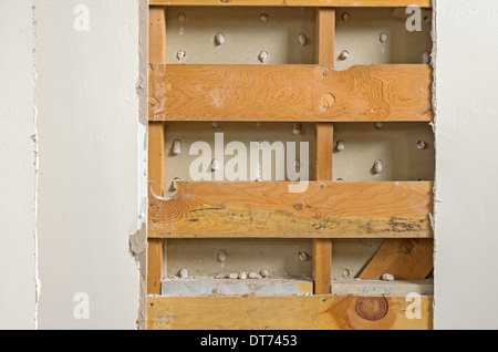 portion of an old interior wall with the dry wall removed exposing wooden boards Stock Photo
