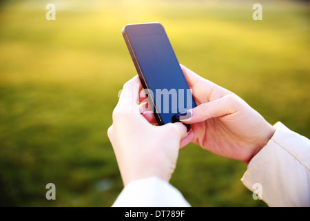 Closeup image of a female hands using smartphone Stock Photo
