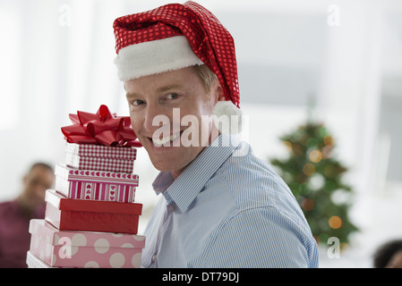 A man in a Father Christmas hat. At home. A decorated Christmas tree. Stock Photo