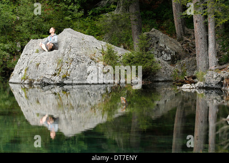 Man praying in front of a lake. Stock Photo