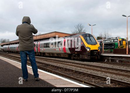A rail enthusiast photographing a diesel train, Leamington Spa, UK Stock Photo