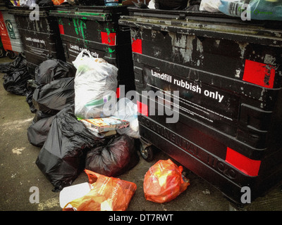 Large wheeled bins for Landfill with overflowing plastic bags Stock Photo