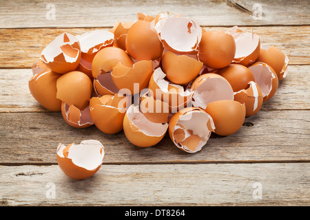 a pile of broken empty brown chicken eggshells on a rustic wooden table Stock Photo