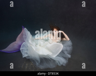 Young redhead mermaid bride, wearing her dress in a pool in Virginia Beach, Virginia. Stock Photo