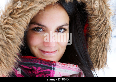 Beautiful young woman with faux fur hood outside on cold winter day Stock Photo