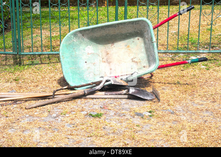 Gardening tools left by the front gate of a house Stock Photo