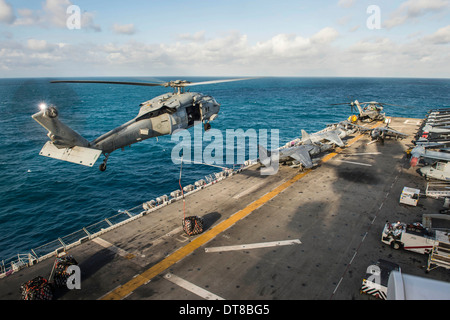 An MH-60S Sea Hawk helicopter delivers supplies to USS Bonhomme Richard. Stock Photo