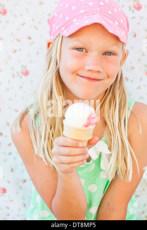 Cute smiling young girl holding ice cream cone Stock Photo