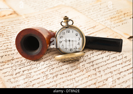 pipe and pocketwatch on letters background Stock Photo