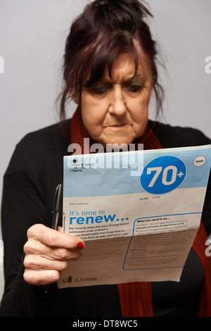 Over 70 year old woman renewing driving licence Stock Photo