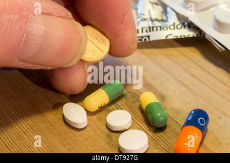 Elderly man's hand with selection of pills, tablets and capsules. Daily dose of medication. Stock Photo