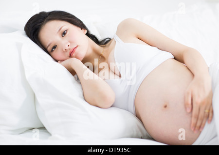 Pregnant woman lying in bed Stock Photo