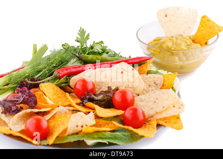 Nachos, cherry tomatoes, lettuce, herbs in plate on white background. Stock Photo