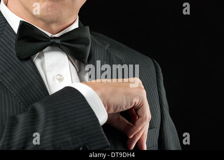 Close-up of a man in a tux tucking in his pocket square. Stock Photo